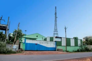 Telecommunication tower near industrial building